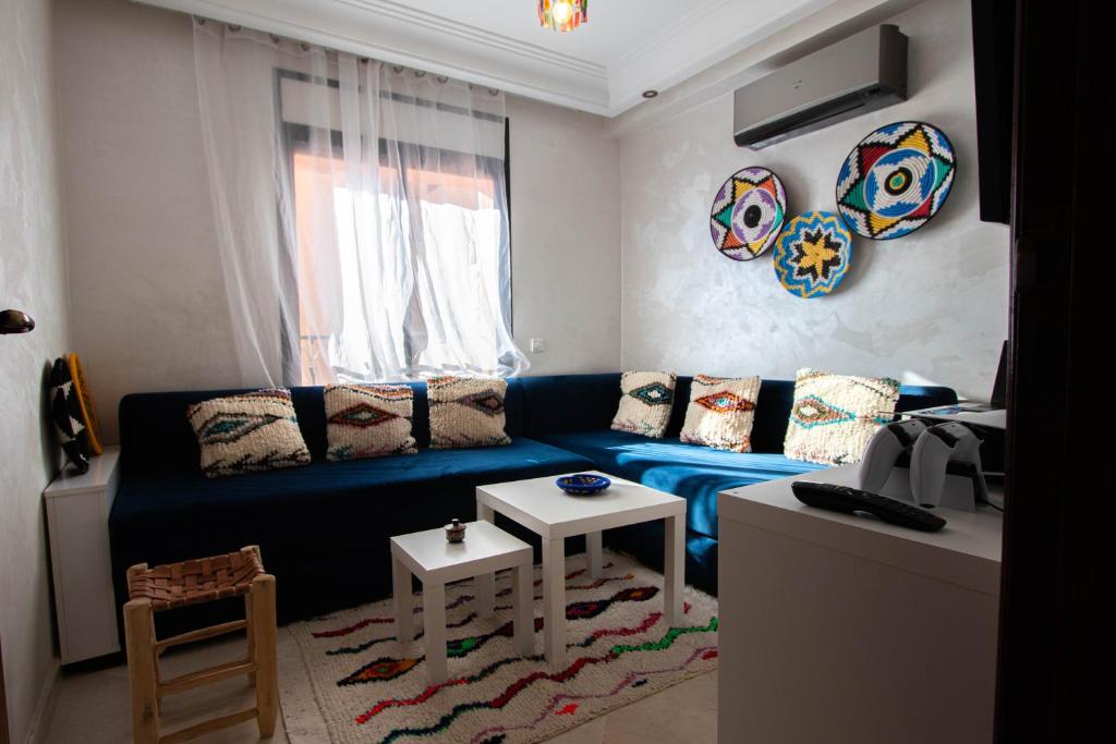 un salon avec un canapé bleu et une table dans l'établissement Cozy I Victor Hugo, à Marrakech