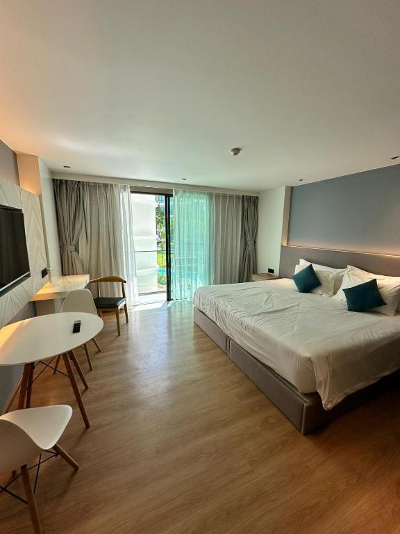 a bedroom with a large bed and a table and chairs at HomeAwayFromHome in Phuket