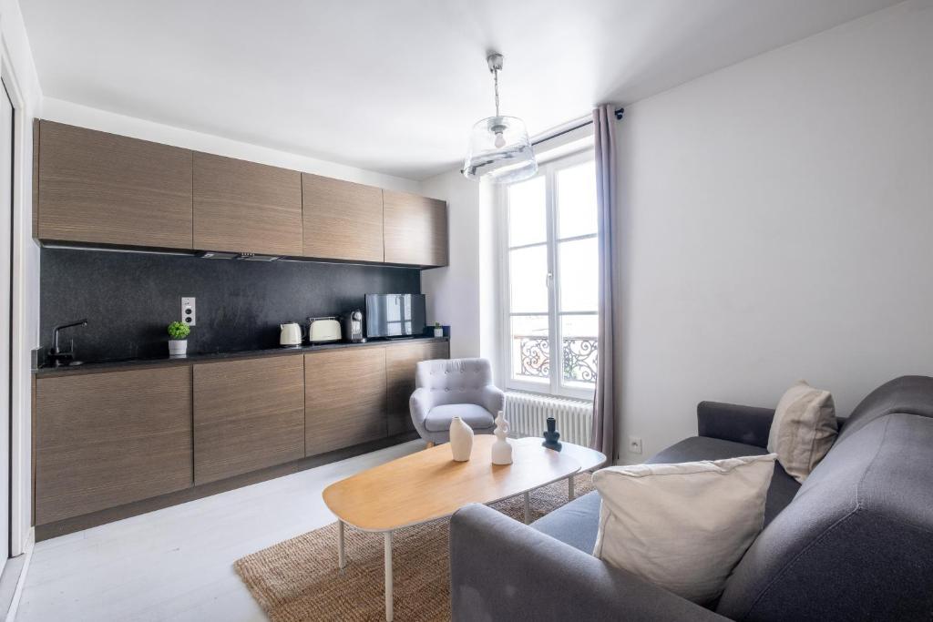 un salon avec un canapé et une table dans l'établissement Havre de Luxe au Pied de Montmartre, à Paris