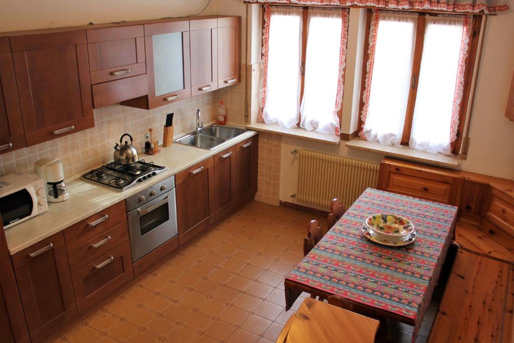 a kitchen with wooden cabinets and a table with a pizza on it at Discover Italy in Tignes
