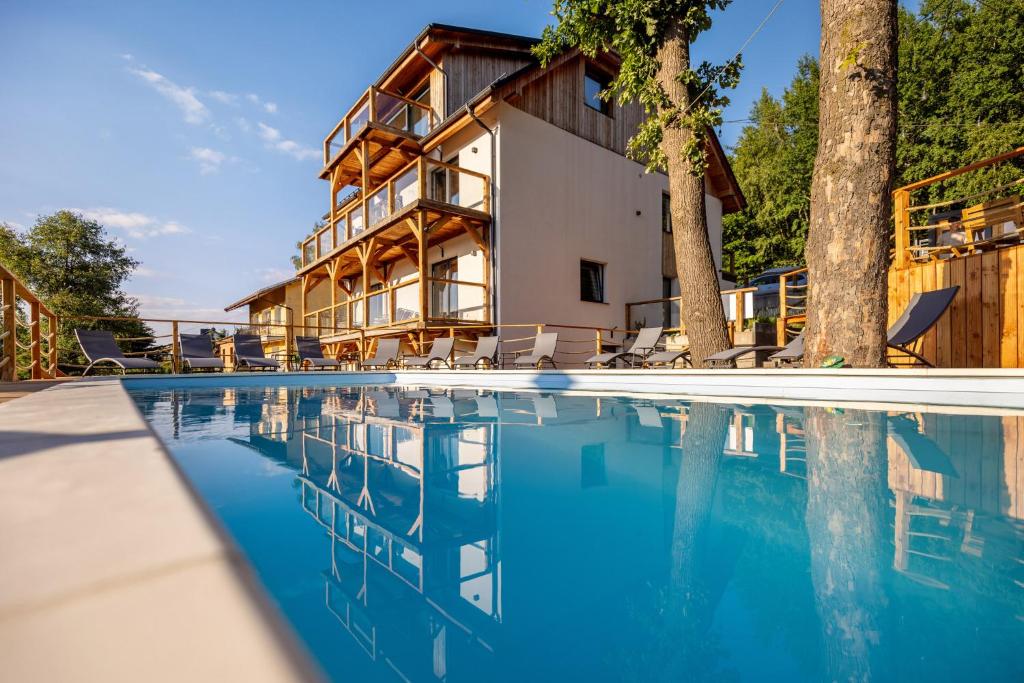 una casa con piscina di fronte a una casa di Apartament Larice VIP - sauna, balia, basen a Świeradów-Zdrój