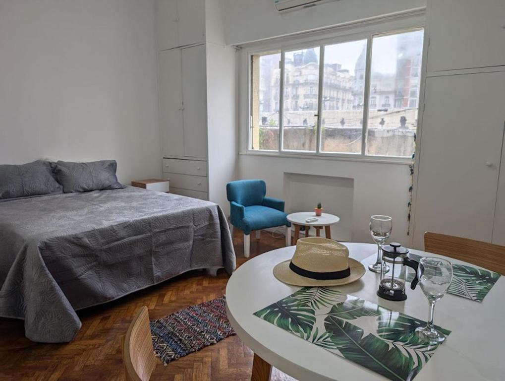 Un dormitorio con una cama y una mesa con un sombrero. en Apartamento central muy luminoso, en Buenos Aires