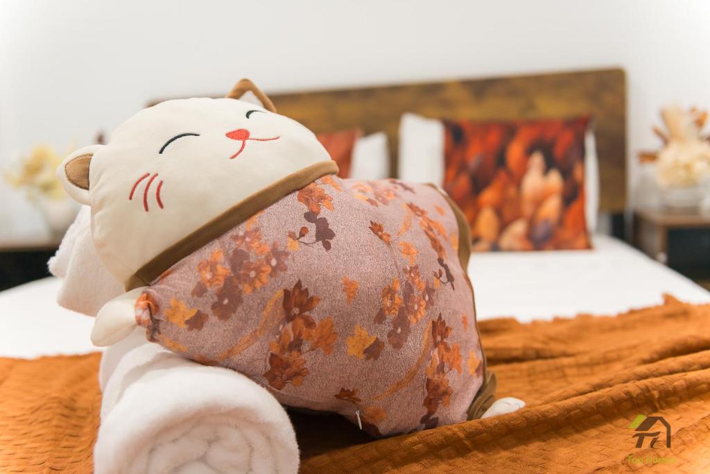 a stuffed cat laying on top of a bed at Cozy&Luminous 4-bedroom house in Ripley