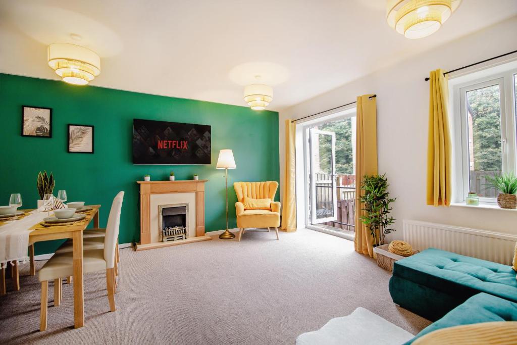 a living room with a green wall and a dining room at Central Cactus Escape Ideal for Long Stays 10ppl! in Nether Edge