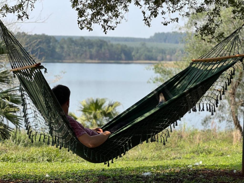 Un uomo sdraiato su un'amaca vicino a un lago di Departamento con vista al lago a Puerto Libertad