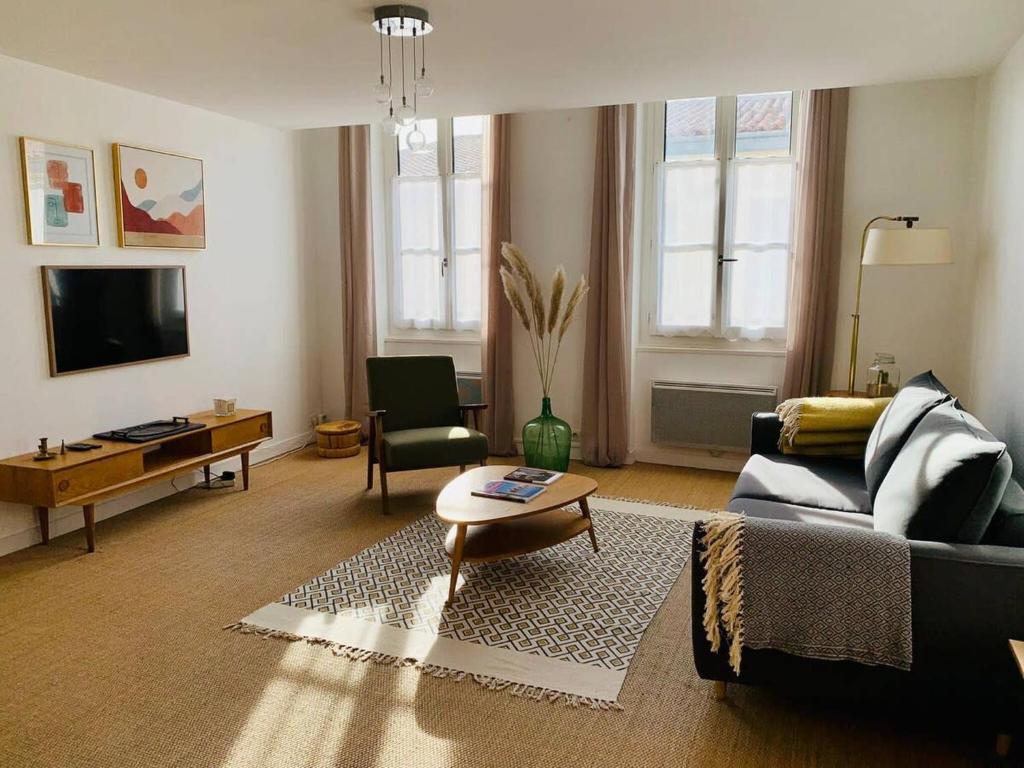 un salon avec un canapé et une table dans l'établissement Le Capricorne Plein Centre Ville La Rochelle Wifi, à La Rochelle