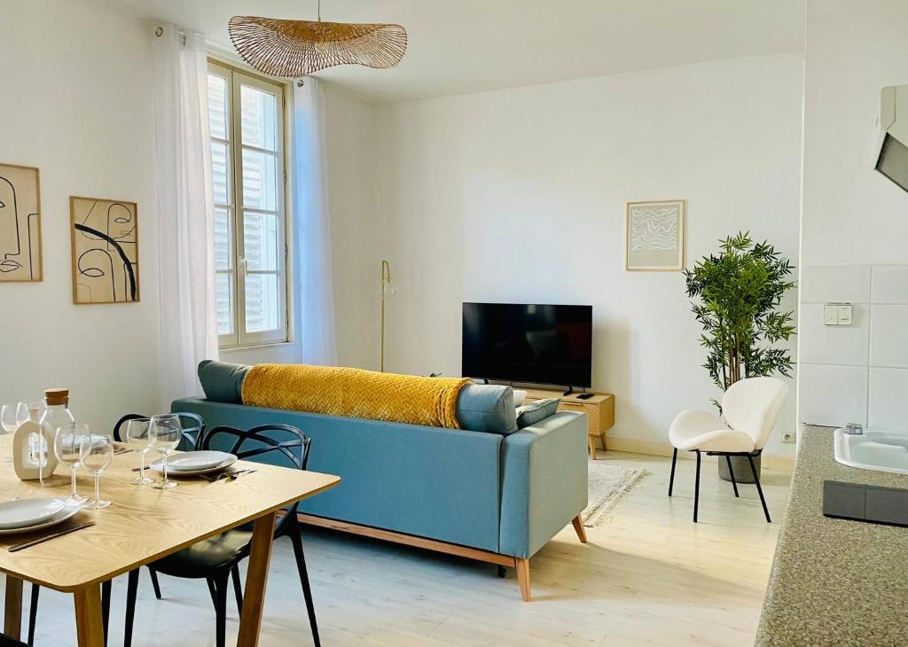 un salon avec un canapé bleu et une table dans l'établissement Le Saint Nicolas - Hypercentre La Rochelle - Wifi, à La Rochelle