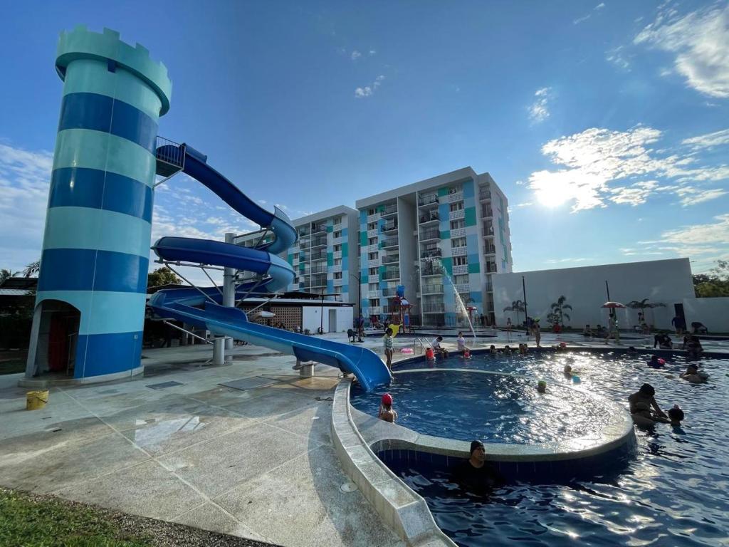 een waterglijbaan in een zwembad met mensen erin bij Apartamento Familiar in Carmen de Apicalá