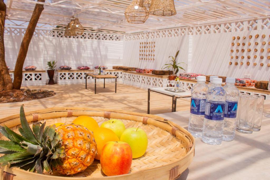 een fruitmand op een tafel met flessen water bij Casa Linda in Harare