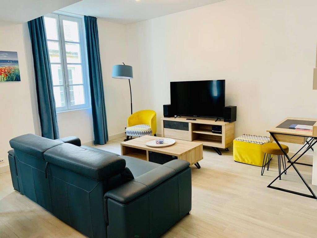un salon avec un canapé et une télévision dans l'établissement Le Grand Cloutiers - Plein Centre Ville - Wifi, à La Rochelle