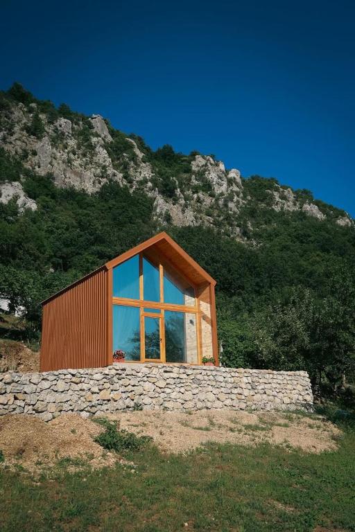 a house with a large window on a mountain at Ostrog Wood House in Železnička Stanica Dabovići