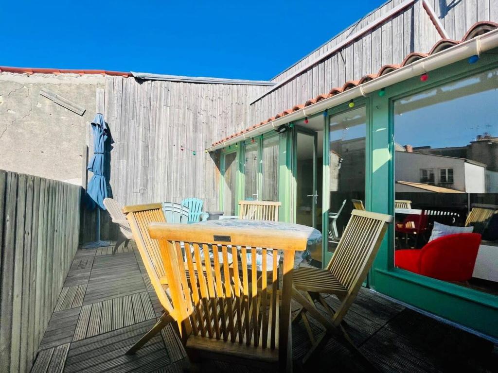 une table et des chaises en bois sur une terrasse dans l'établissement La Cabane - T3 Avec Terrasse Plein Centre Ville LR, à La Rochelle