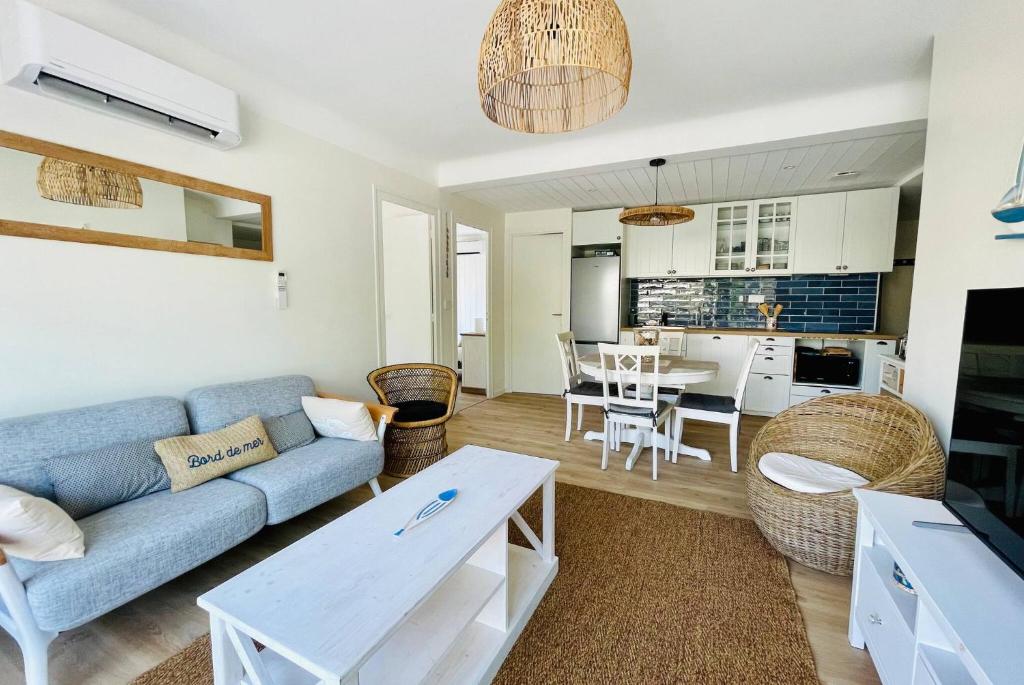 un salon avec un canapé bleu et une cuisine dans l'établissement L Escapade Rochelaise - Wifi & Balcon, à La Rochelle