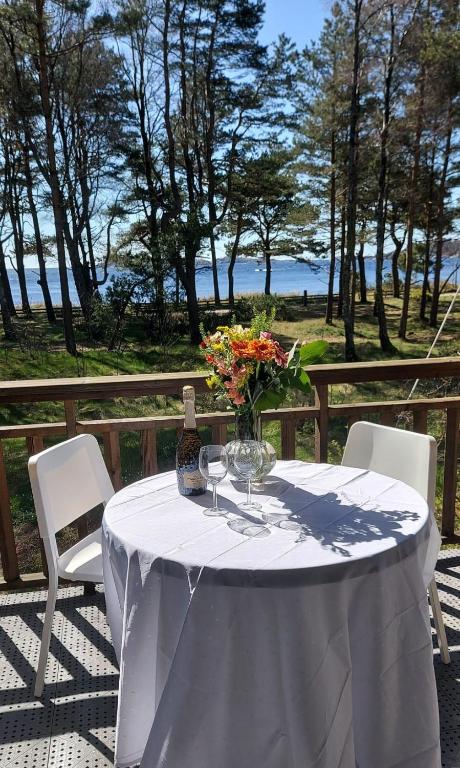 a table with two chairs and a vase of flowers at Leilighet rett ved stranden in Mandal
