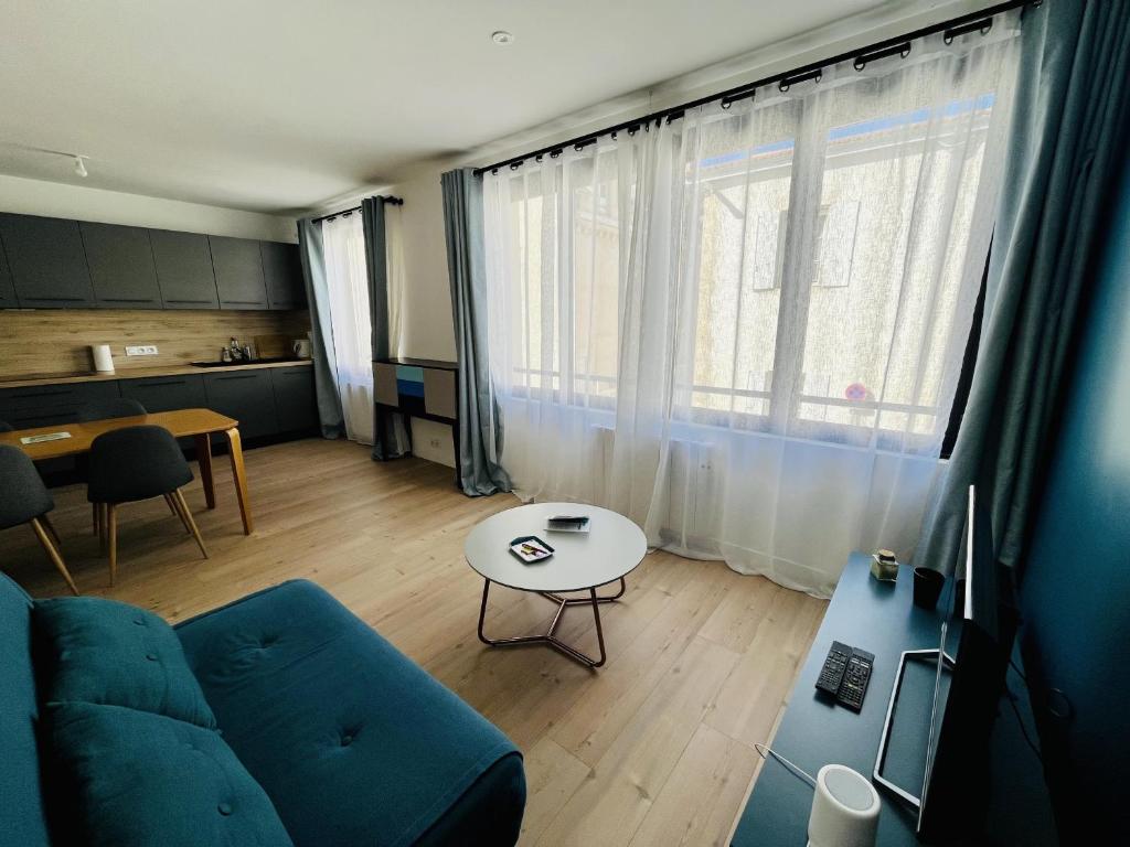 un salon avec un canapé bleu et une table dans l'établissement La Fonderie 1er etage - Centre Ville La Rochelle Wifi, à La Rochelle