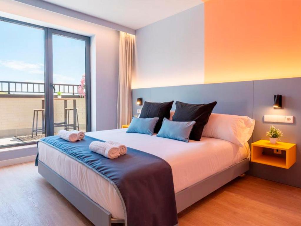 a bedroom with a large bed with a large window at La marina sunset 3000 in Soto de la Marina