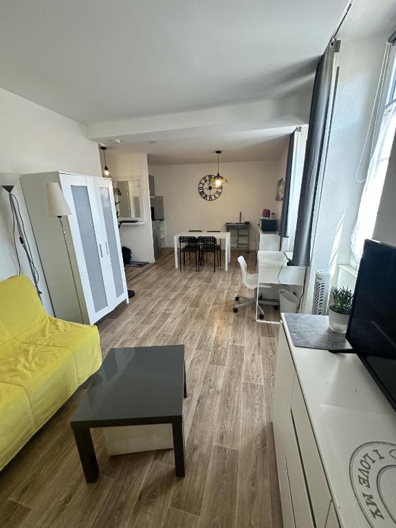 - un salon avec un lit jaune et une table dans l'établissement Coeur de ville - studio pour 2 personnes, à La Rochelle