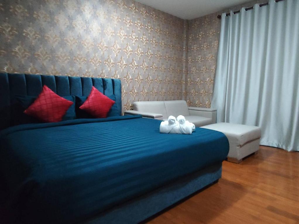 a bedroom with a blue bed with red pillows at แกร็บสลีปโฮสเทล แอร์พอร์ตดอนเมือง in Ban Ko