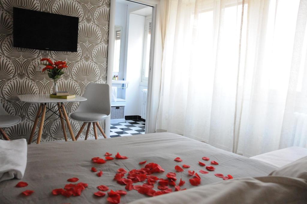 una camera da letto con rose rosse su un letto di Alma Mater B&B a Roma