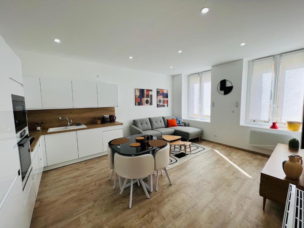 une cuisine et un salon avec une table et un canapé dans l'établissement Appartement Moderne Centre-Ville, à Saint-Étienne