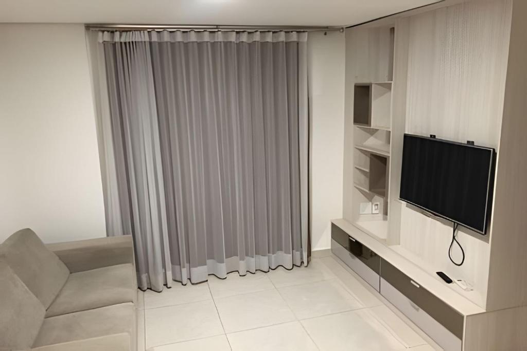 a living room with a television and a couch at iFlat Brookfield Towers BT2901 Jardim Goiás in Goiânia