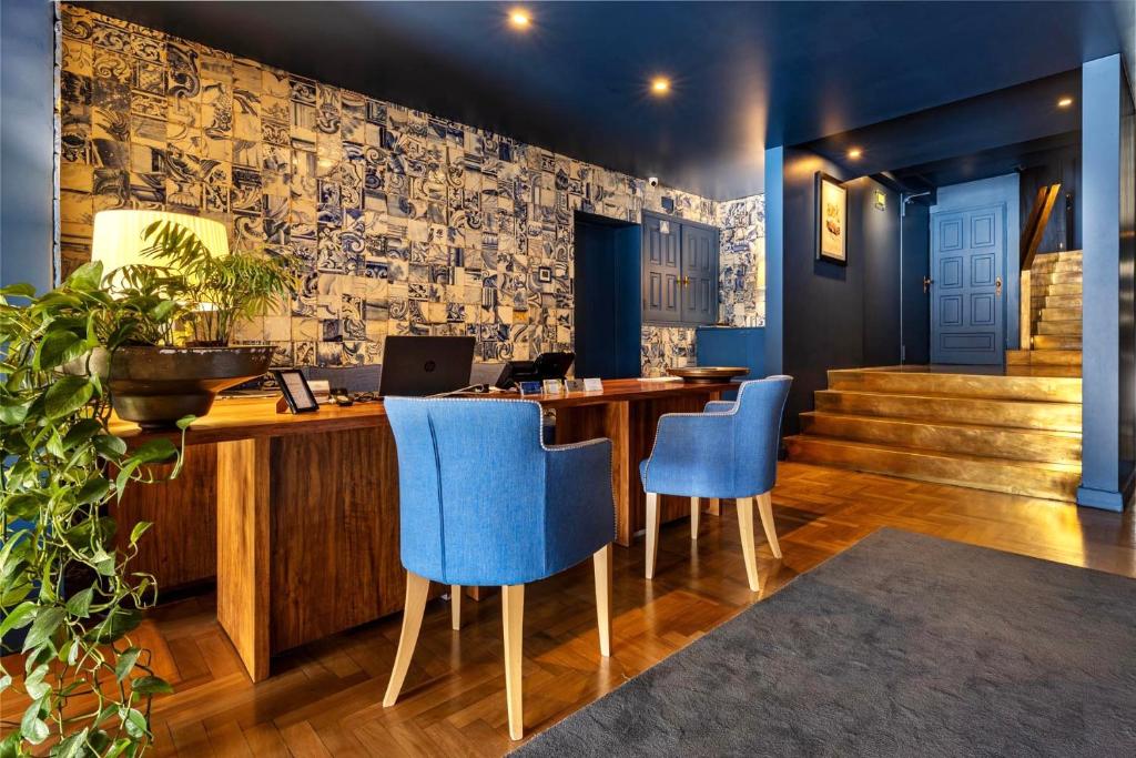 a bar with blue chairs and a desk with a laptop at Villa Cascais Boutique Hotel in Cascais