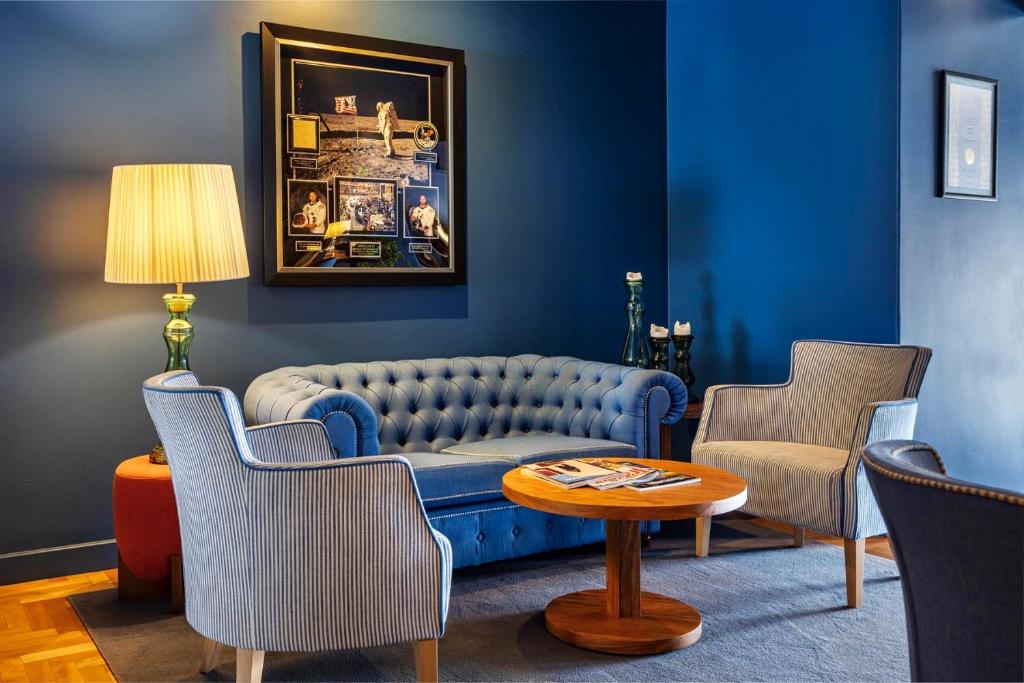 a living room with a blue couch and chairs at Villa Cascais Boutique Hotel in Cascais