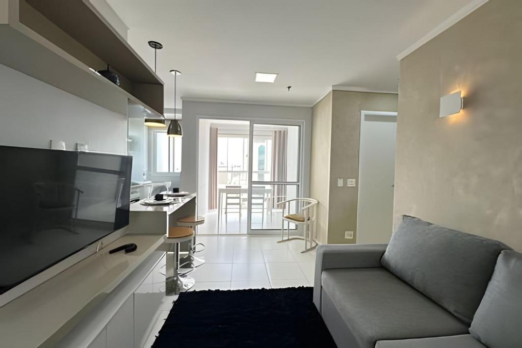 a living room with a couch and a kitchen at iFlat Metropolitan Barcelona MB1003B Jardim Goiás in Goiânia