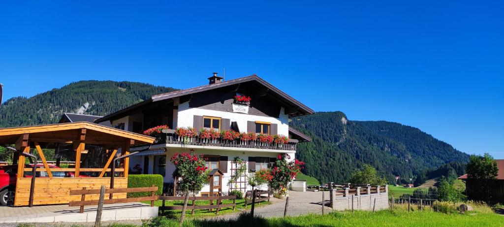 a house with flowers on the balcony of it at Gästehaus Vogler Oberstdorf-Kornau in Oberstdorf