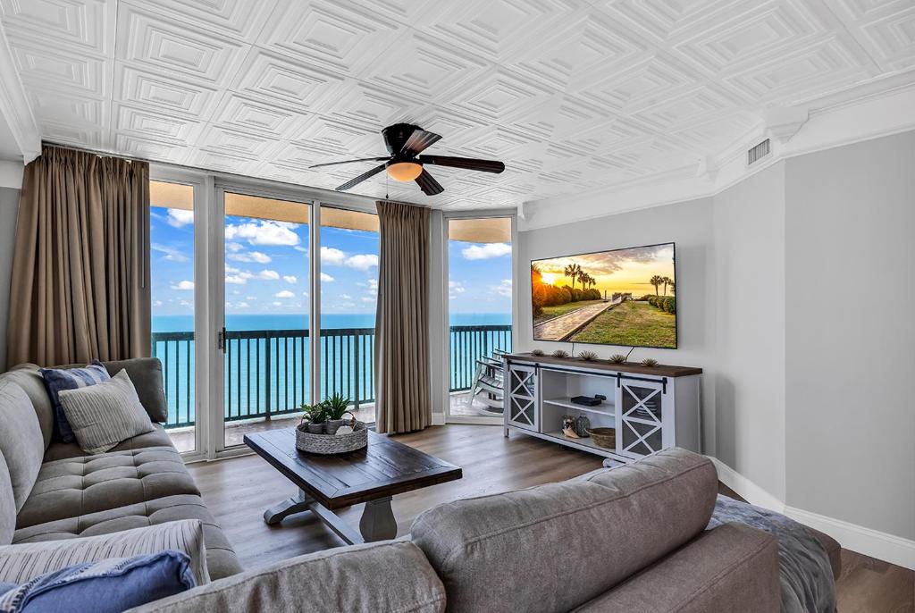 a living room with a couch and a ceiling fan at 4BR Oceanfront Corner Condo NMB in Myrtle Beach
