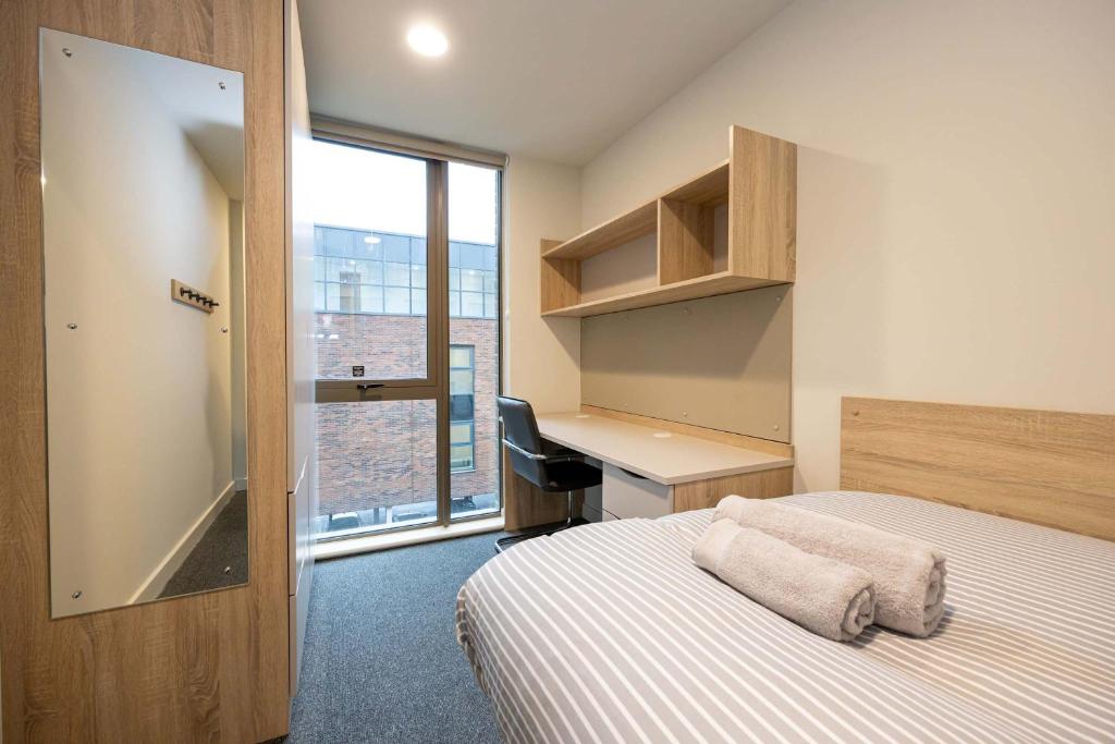 a bedroom with a bed and a desk and a window at Practical Room For One, Central Nottingham in Nottingham