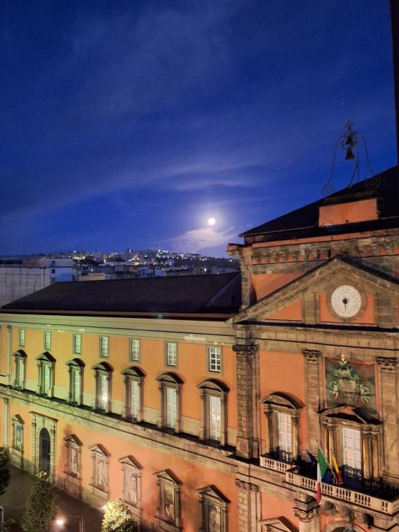 a building with a clock on top of it at night at B&B Museum in Naples