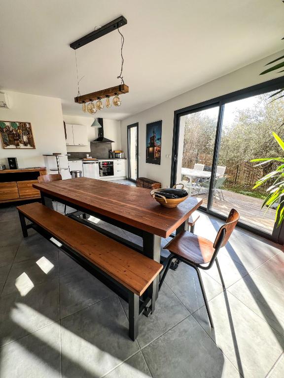 une salle à manger avec une table et des chaises en bois dans l'établissement L'olivette de Sommières, belle maison calme à quelques minutes du centre ville historique, à Sommières