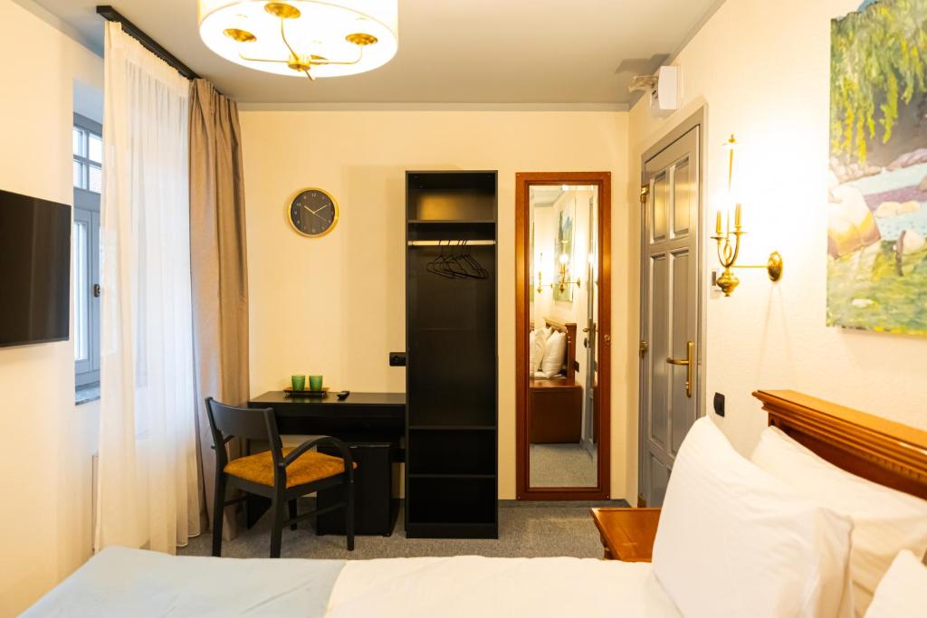 a bedroom with a bed and a desk and a table at Epic rooms in Braşov