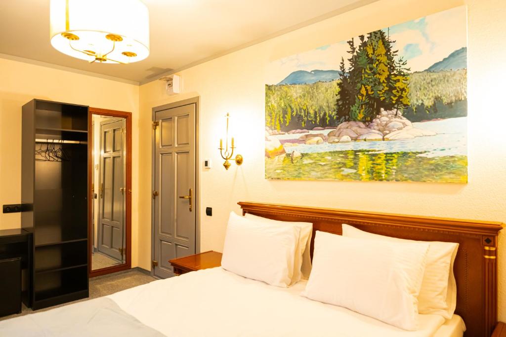 a bedroom with a bed and a painting on the wall at Epic rooms in Braşov