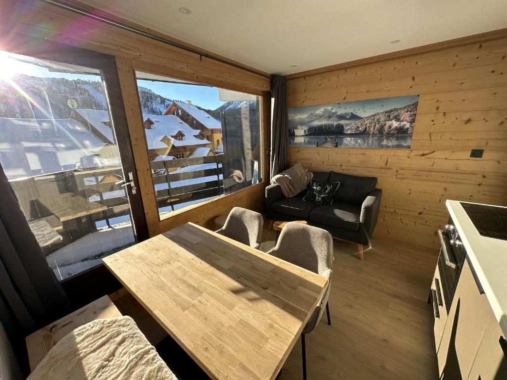 un salon avec une table et un canapé dans l'établissement Appartement rénové cosy avec belle vue, à Montgenèvre