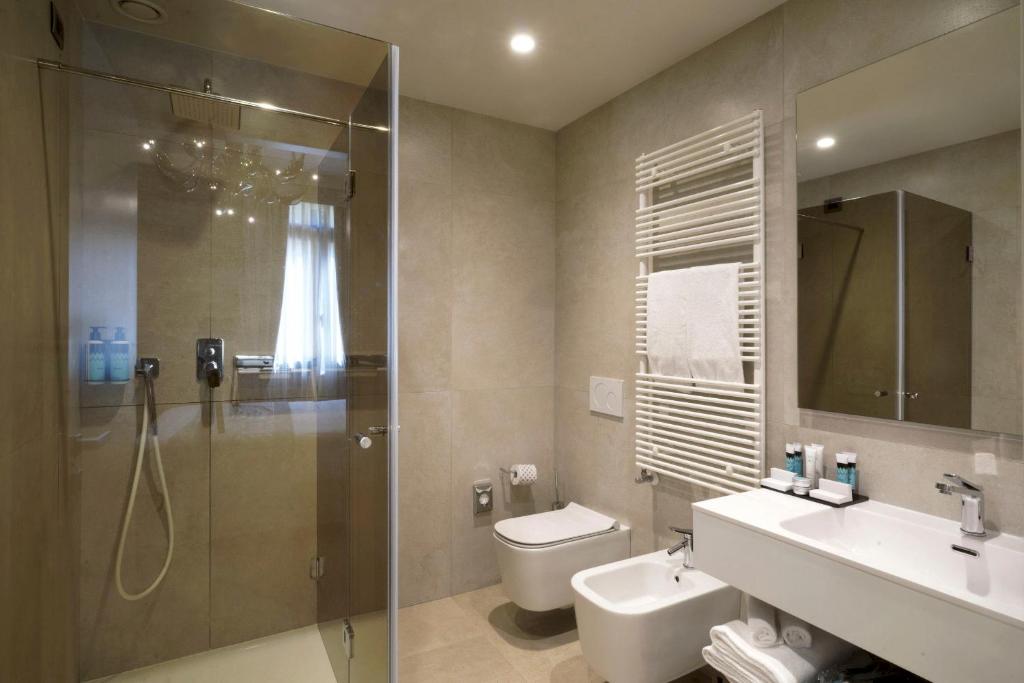a bathroom with a shower and a toilet and a sink at Hotel Aquarius Venice - Ascend Collection in Venice