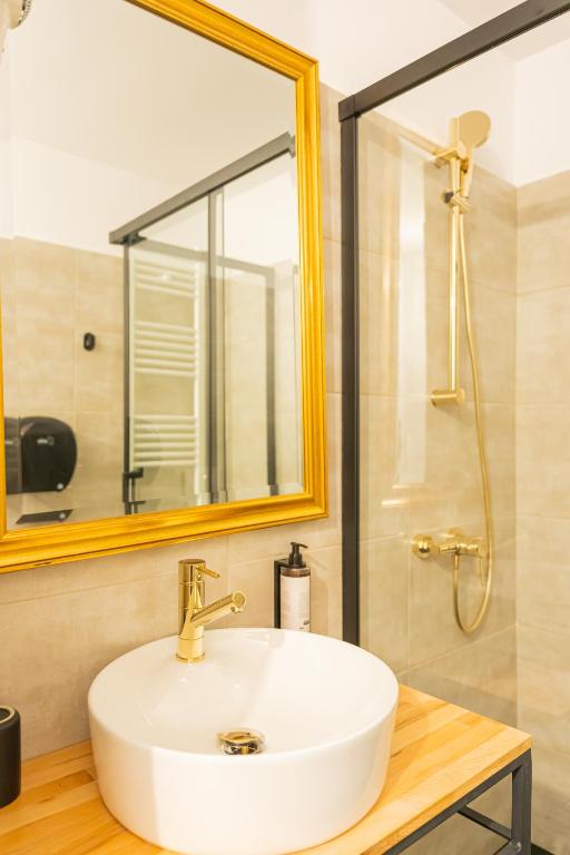 a bathroom with a white sink and a shower at Epic rooms in Braşov