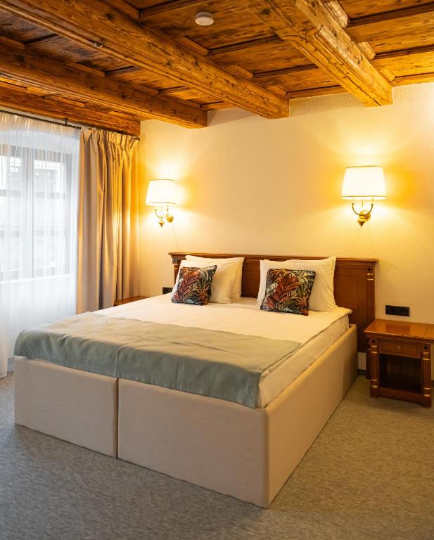 a bedroom with a large bed with two lamps at Epic rooms in Braşov