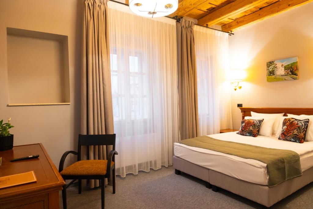 a bedroom with a bed and a desk and a window at Epic rooms in Braşov