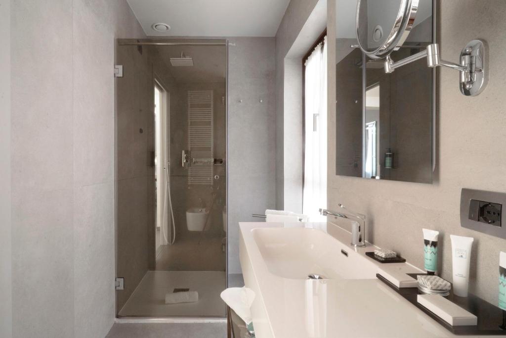 a bathroom with a sink and a mirror and a shower at Hotel Aquarius Venice - Ascend Collection in Venice