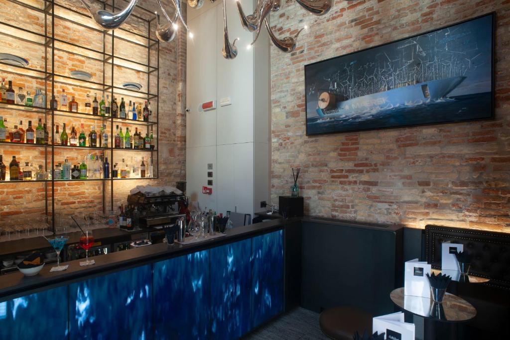 a bar with a blue counter and a brick wall at Hotel Aquarius Venice - Ascend Collection in Venice