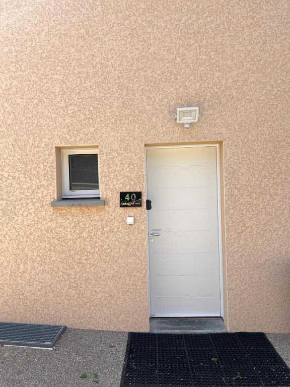 une porte menant à un bâtiment avec une fenêtre dans l'établissement Maison 40 avec 5 chambres lechaffardcom, à Satolas-et-Bonce