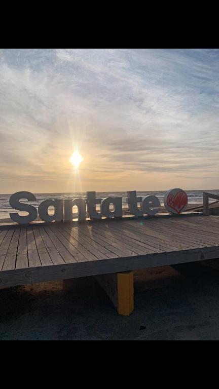 a bench on a pier with the sun in the background at Bella Casa La Costa in Santa Teresita