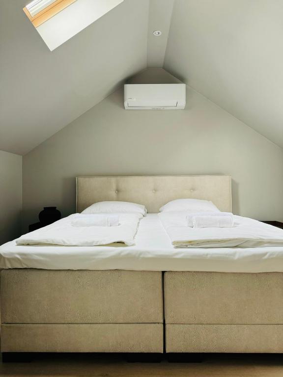een groot bed in een kamer met een dak bij Hello Katwijk - Zomerhuis Paul Krügerstraat 3 in Katwijk aan Zee