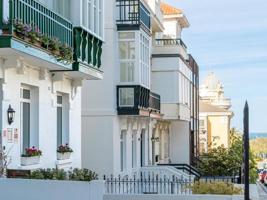 - un bâtiment blanc avec balcon dans une rue dans l'établissement Casa Anzano, à Santander