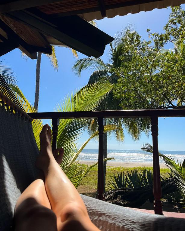 a person laying in a hammock looking out at the beach at Redwood Beach Resort in Mechapa
