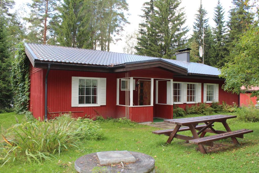 una cabaña roja con una mesa de picnic delante de ella en Villa Red House, en Parikkala