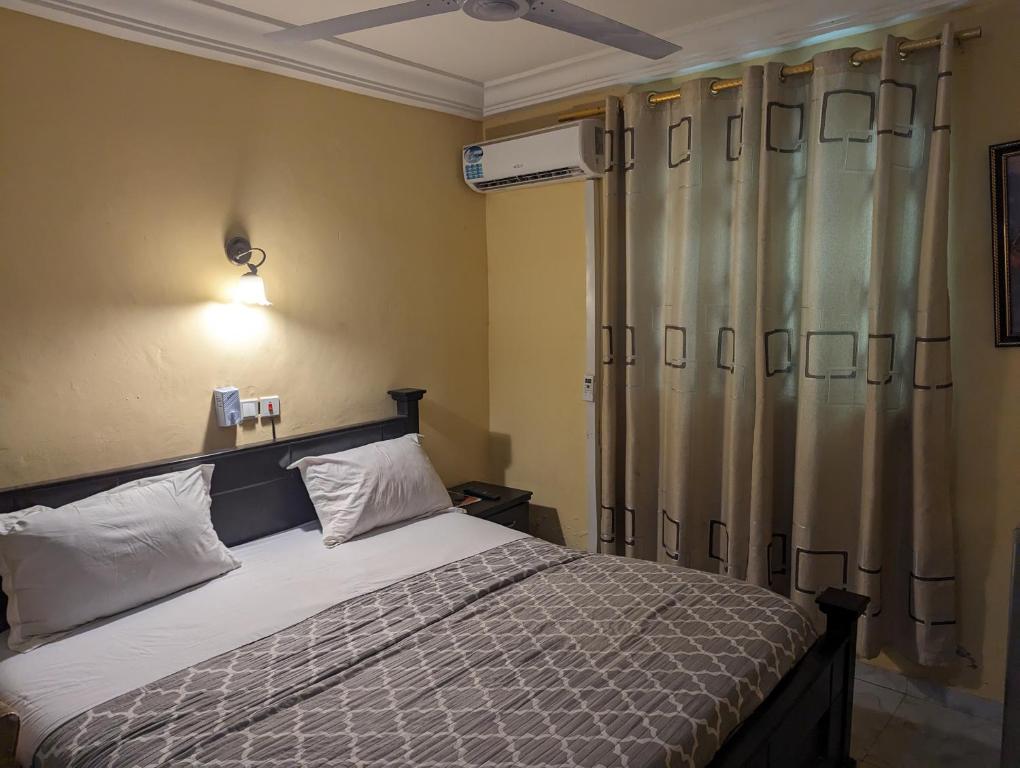 アクラにあるGordon's Executive Lodge Hotelのベッドルーム1室(ベッド1台、シャワーカーテン付)