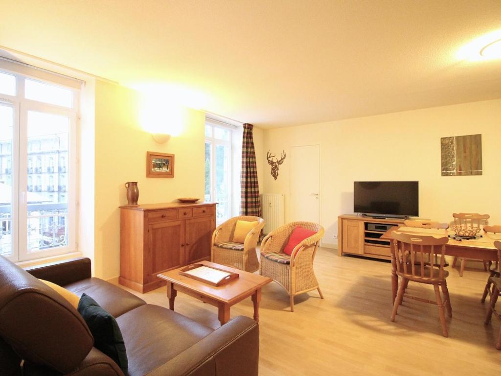 un salon avec un canapé et une table dans l'établissement Charmant T2 bis centre La Bourboule, WIFI, parking, proche thermes - FR-1-608-56, à La Bourboule